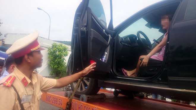 CSGT cẩu xe về trạm, nữ tài xế vẫn cố thủ trong ô tô