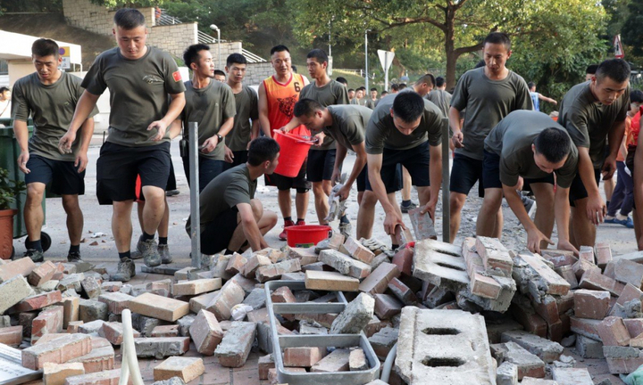 Binh sỹ Trung Quốc mặc áo phông, xách xô xuống đường Hong Kong dọn dẹp