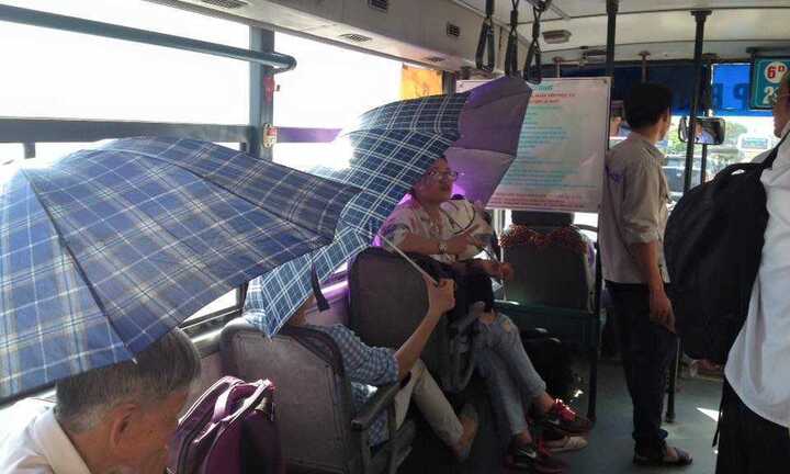 Nắng nóng gần 40 độ C, người Hà Nội che ô đi xe buýt