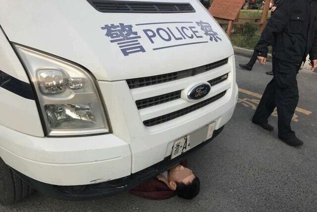 Vợ bị cảnh sát bắt, chồng chui gầm xe 'ăn vạ'