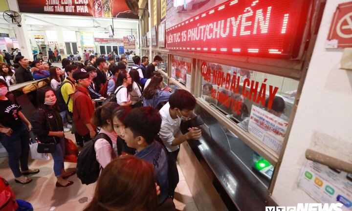 Chen chúc xếp hàng, ăn vội bánh mì trong lúc vạ vật chờ mua vé xe về quê