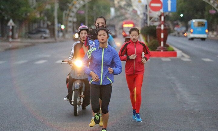 HLV đi xe máy, soi đèn giúp học trò tập chạy từ tờ mờ sáng
