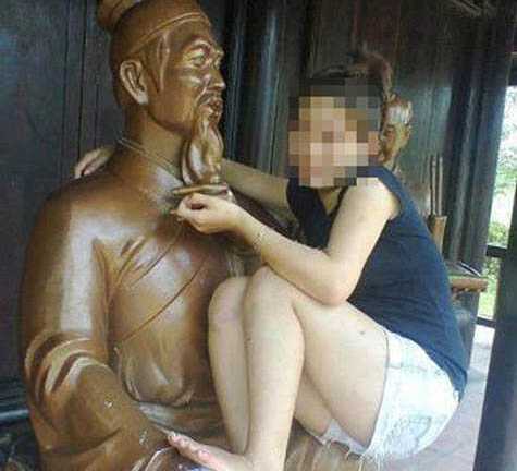 Cô gái tạo dáng phản cảm trên tượng danh nhân
