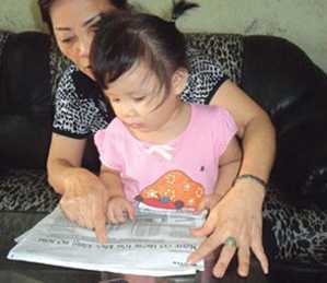 Cháu bé 2 tuổi đọc báo trôi chảy