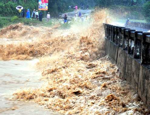 Qua cầu bất cẩn, học sinh tiểu học bị lũ cuốn trôi
