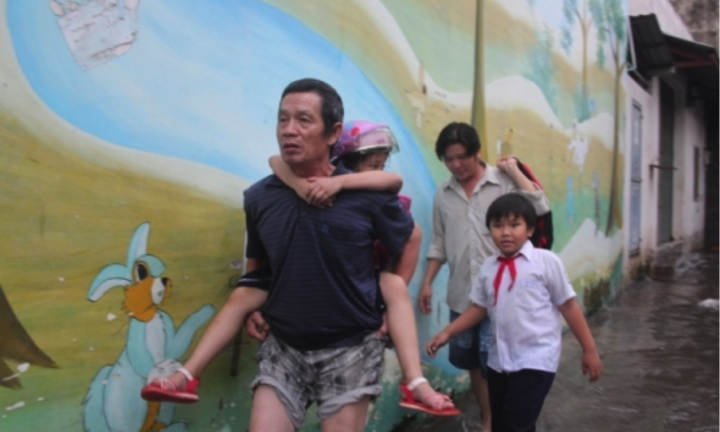 TP.HCM mưa ngập, phụ huynh bì bõm cõng con về