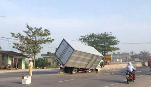 Xe tải bay lên dải phân cách, hai bánh văng xa