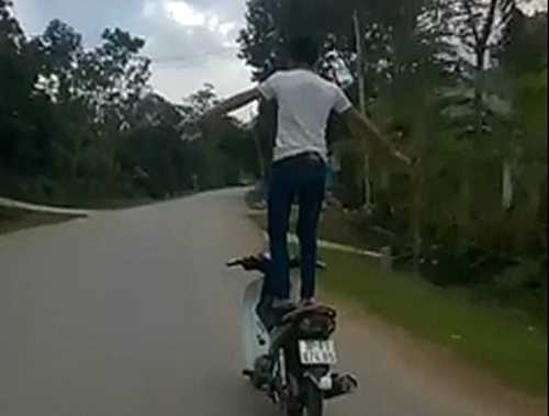 Nam thanh niên đứng thả 2 tay trên xe máy chạy tốc độ cao