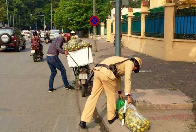 Ấm lòng hình ảnh CSGT nhặt cam giúp người dân