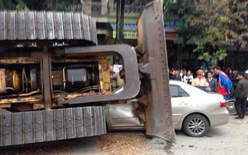 Máy ủi rơi đè nát đầu ôtô, tài xế thoát chết trong gang tấc