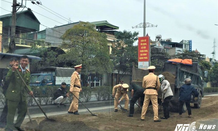 CSGT xúc cát ngăn vết dầu loang, giúp xe cộ không bị trượt ngã