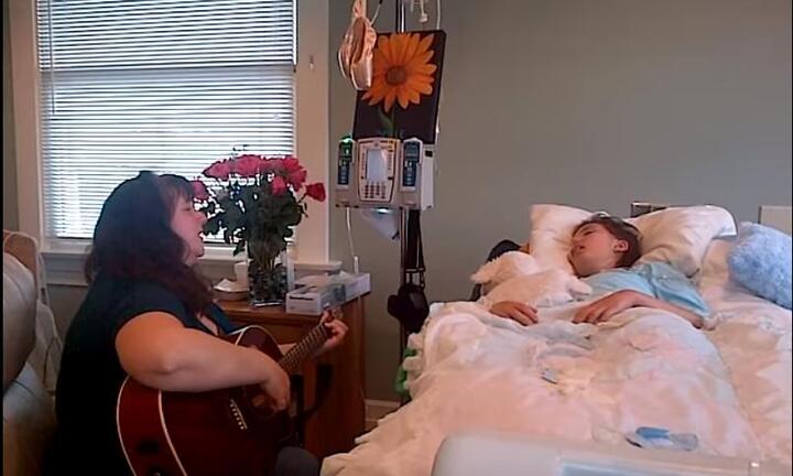 Xúc động khoảnh khắc người mẹ gảy đàn hát vĩnh biệt con gái đang hấp hối vì ung thư