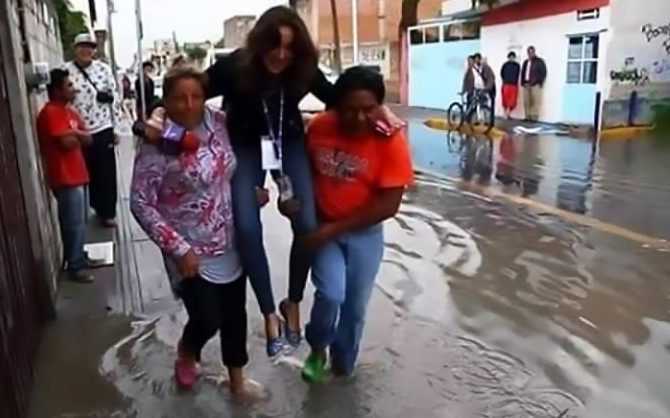 Nữ phóng viên bị chỉ trích dữ dội vì để người dân bế qua nước ngập