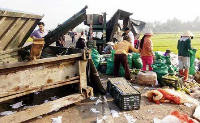 Xe container bị lật, dân Bình Định lao vào gom 30 tấn trái cây giúp tài xế