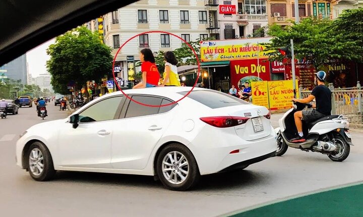 Tài xế chở 2 bé gái ngồi nóc ô tô sẽ bị xử phạt thế nào?