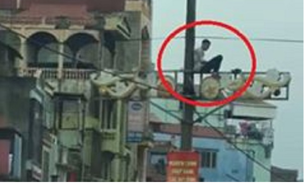 Nam thanh niên nghi ngáo đá ngồi trên cột điện ở Hà Nội