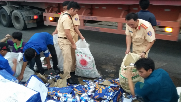 Cảnh sát giao thông giúp tài xế gom hàng trăm thùng bia đổ trên cầu