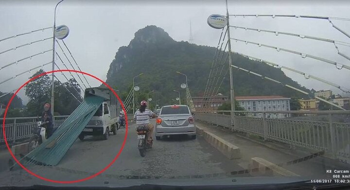 Xe tải đánh rơi tấm tôn sắc như dao, người đi đường thoát chết trong gang tấc
