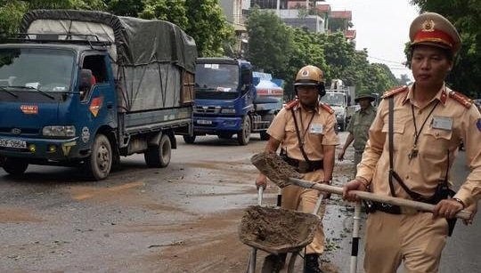 Xe máy trượt ngã do vết dầu loang trên phố, CSGT xúc cát rải đường