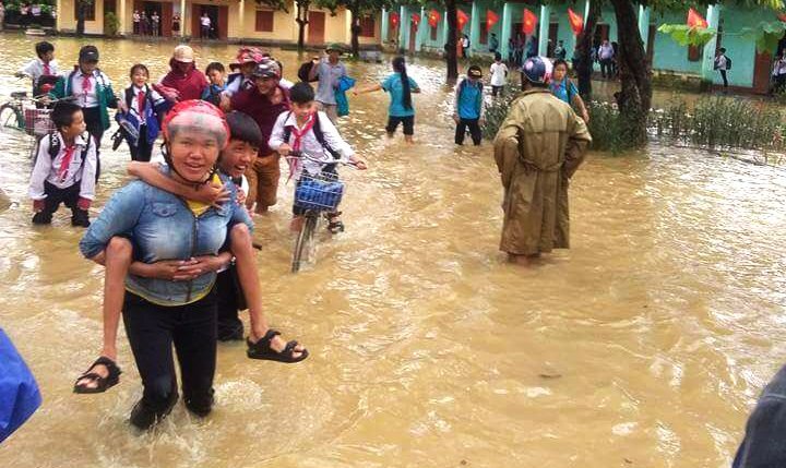 Đường phố Nghệ An biến thành sông, phụ huynh lội bì bõm đến trường cõng con về