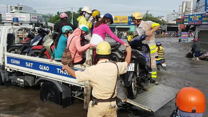 Video: CSGT lội nước, dùng xe công vụ giúp dân vượt đường ngập