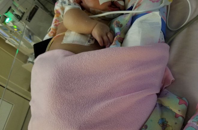 Được người nhà ôm hôn, em bé nhiễm virus viêm phổi