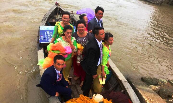 Chú rể mặc áo mưa đi ghe vượt lũ đón cô dâu trong đám cưới ở Bình Định