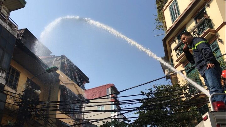 Ảnh: Cảnh sát phun nước dập tắt đám cháy trên phố trung tâm Hà Nội