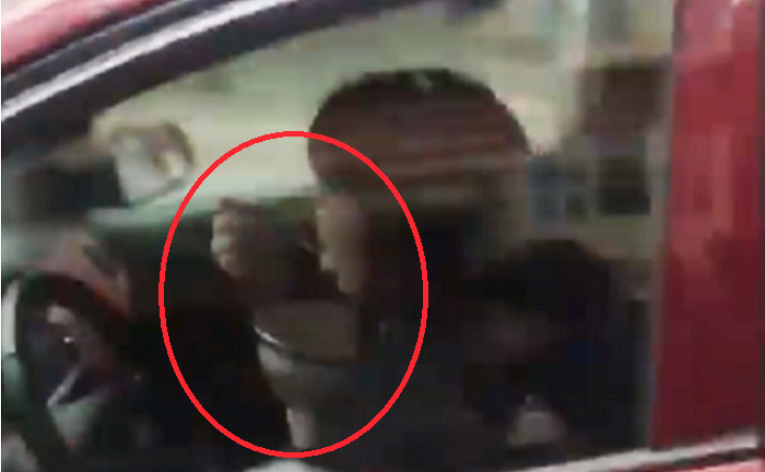 Nữ tài xế vừa lái ô tô vừa bê bát ăn trên phố Hà Nội