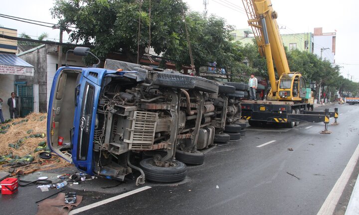 Xe tải chở dưa hấu đâm đổ cột đèn rồi lật ngửa giữa đường