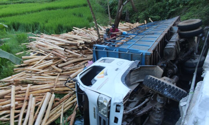 Xe tải chở gỗ lật xuống suối, tài xế thoát chết trong gang tấc