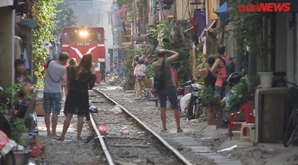 Video: Khách Tây liều mạng đổ xô ra sát đường ray chụp ảnh tàu chạy ở Hà Nội