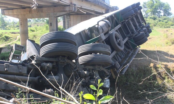 Va chạm với xe khách, xe đầu kéo lật nhào xuống mương nước