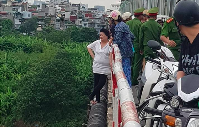 Người phụ nữ đứng vắt vẻo trên thành cầu Chương Dương chửi bới, đòi tự tử