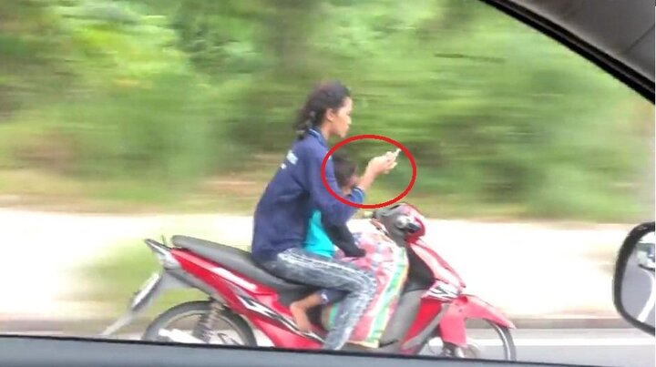 Clip: Phụ nữ đi xe máy đèo trẻ nhỏ, buông cả 2 tay nhắn tin gây sốc