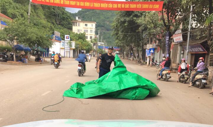 Clip: Bạt bay từ nóc ô tô tải trùm gọn anh chàng đi xe máy