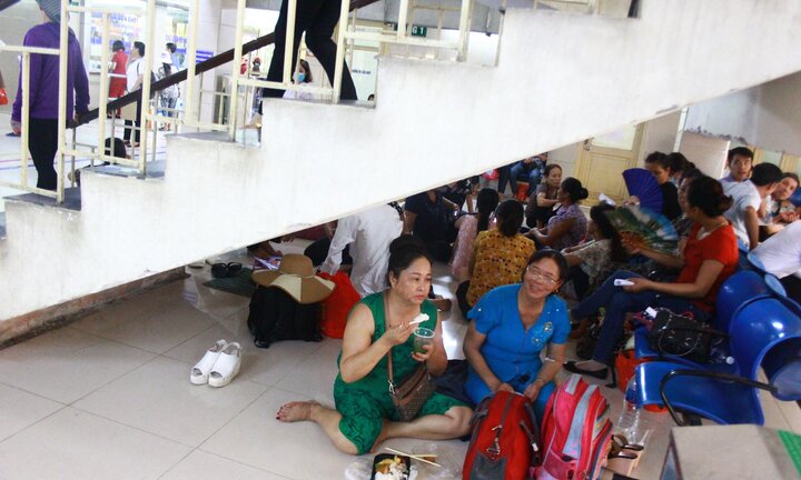 Nắng nóng kỷ lục ở Hà Nội, bệnh nhân bê cơm ăn dưới gầm cầu thang chờ được khám