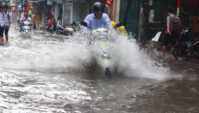 Ảnh: Dân Thủ đô bì bõm lội nước về nhà sau cơn mưa lớn