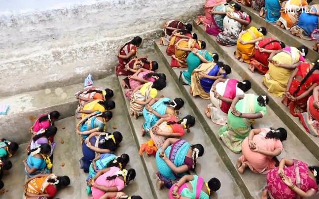 Choáng với cảnh hàng trăm phụ nữ quỳ gối ăn cơm trộn cát