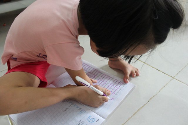 Cô bé 8 tuổi không tay, viết chữ đẹp bằng chân