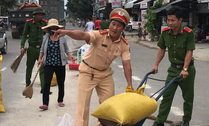 Cảnh sát giao thông dọn đá rơi vãi trên quốc lộ ở Bình Định