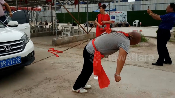 Video: Cao thủ kungfu Trung Quốc dùng một tai kéo hai ô tô chở đầy người