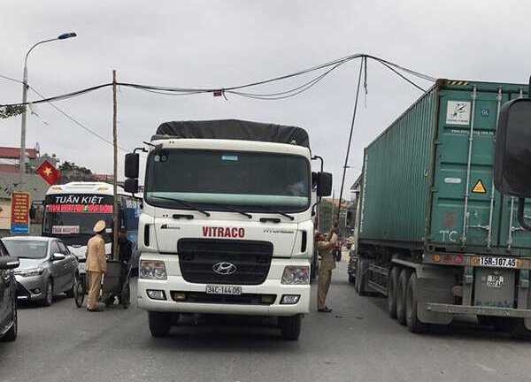 Đổ cột điện giữa trưa, CSGT thay nhau chống dây điện cho ô tô đi qua