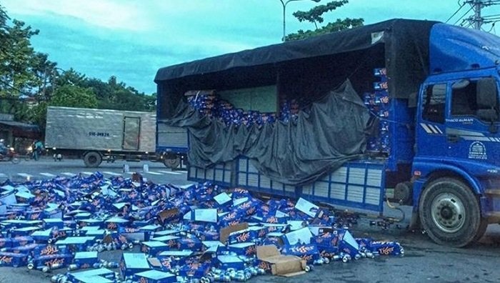 Người dân giúp đỡ tài xế thu dọn hàng trăm thùng bia đổ xuống đường