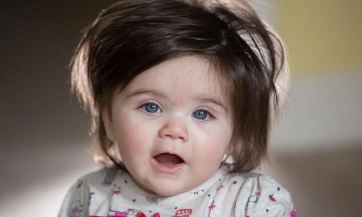 Bé gái 7 tháng tuổi có mái tóc dài, bồng bềnh đen nhánh