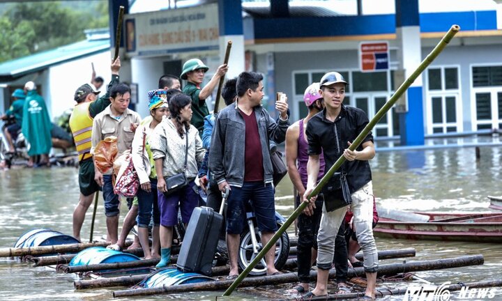 Ảnh: Đưa dân vượt quốc lộ 6 ngập sâu bằng bè mảng