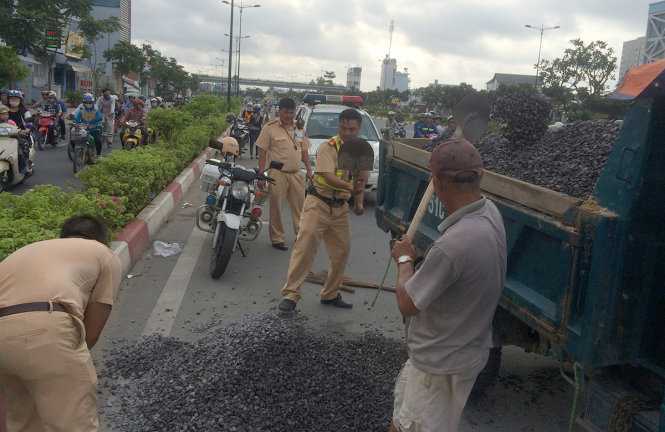 Bốn chiến sỹ CSGT đội nắng, thuê xe hốt đá dăm vương vãi trên đường