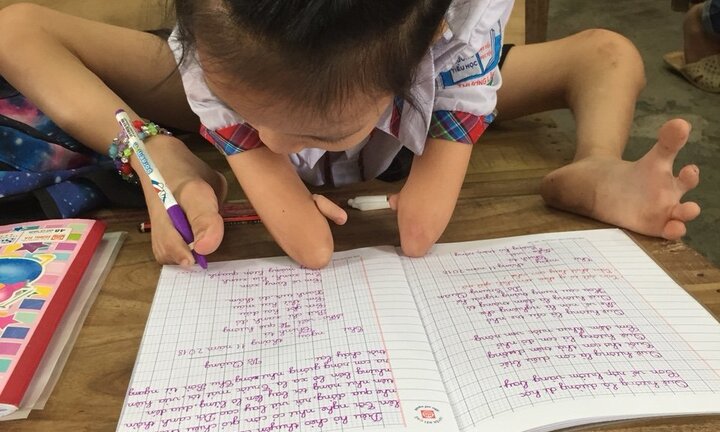 Ảnh: Giờ học của cô bé 8 tuổi cụt tay, dùng chân nắn nót viết chữ đẹp