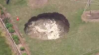 Kinh hãi 'hố tử thần' khổng lồ cuồn cuộn nước xuất hiện sau nhà dân