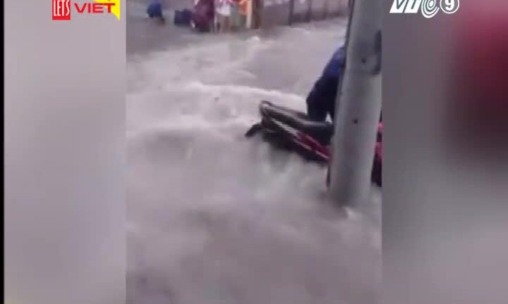 Nước cuồn cuộn trên đường cuốn phăng xe máy ở TP.HCM